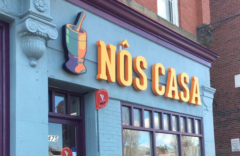 Blue facade with orange and yellow "Nos Casa" sign