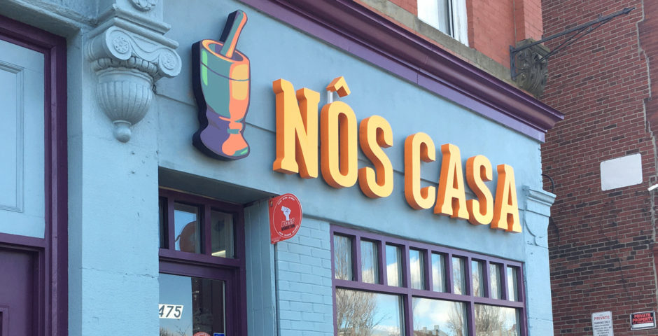 Blue facade with orange and yellow "Nos Casa" sign